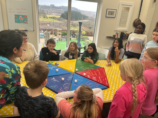 Children's Parliament group discuss ideas around a participation cake.