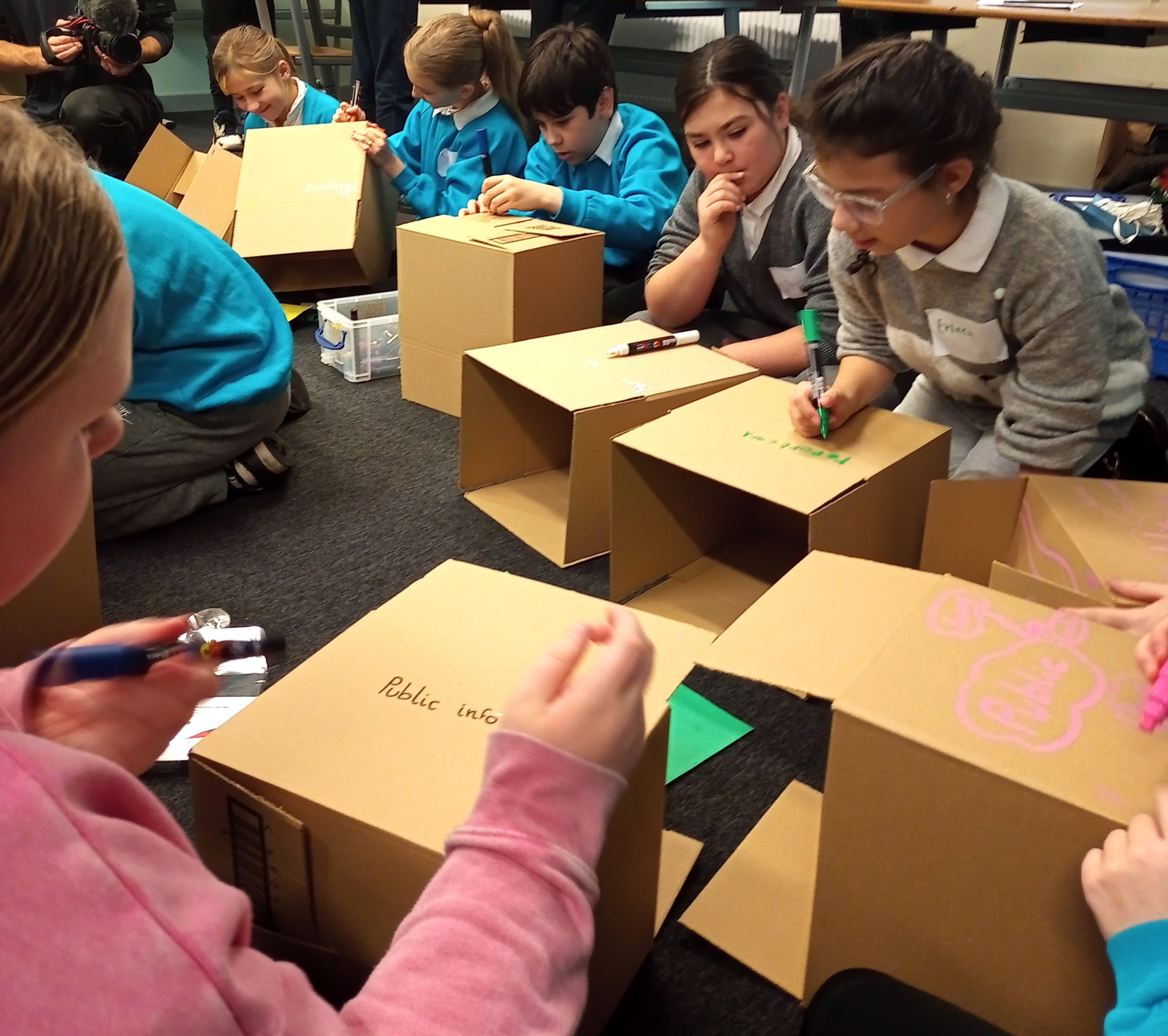 Members of Childrens Parliament work on the floor to engage in a creative process while Exploring Childrens Rights and A.I (2025)